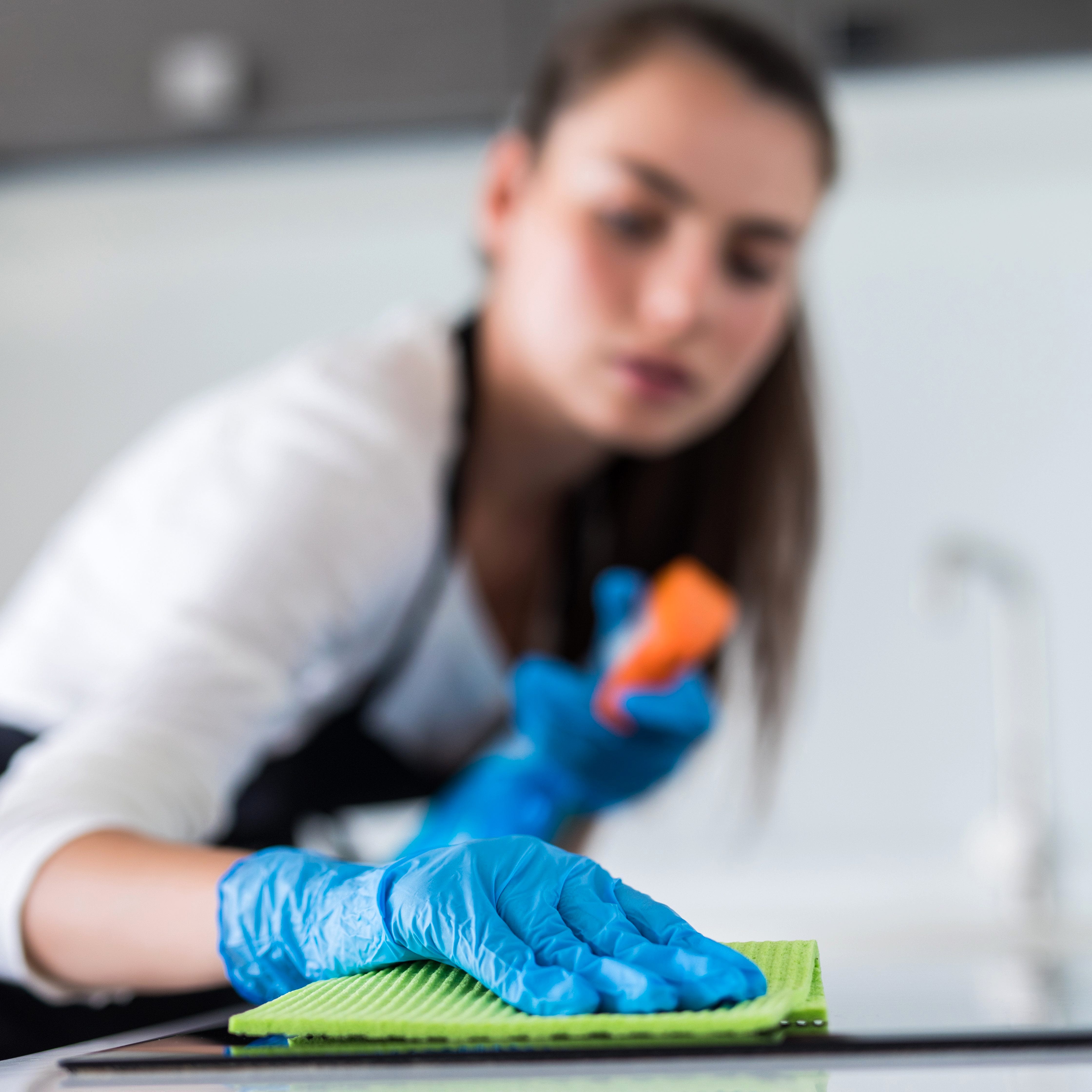 young smiling woman cleans the kitchen at home